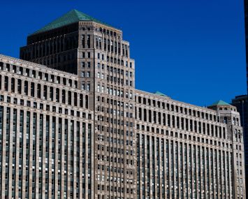 A large, blockish, stone office building with many windows.
