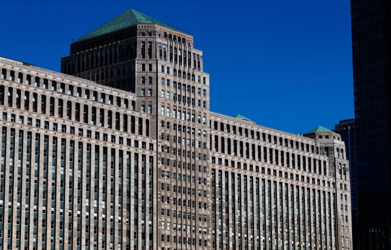 A large, blockish, stone office building with many windows.