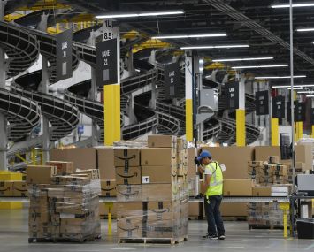 A warehouse associate wraps plastic around a pallet load of boxes at Amazon's fulfillment center. Demand has increased for industrial warehousing assets that support quicker supply chains, as well as supply chains that can move single items rather than large items or containers.