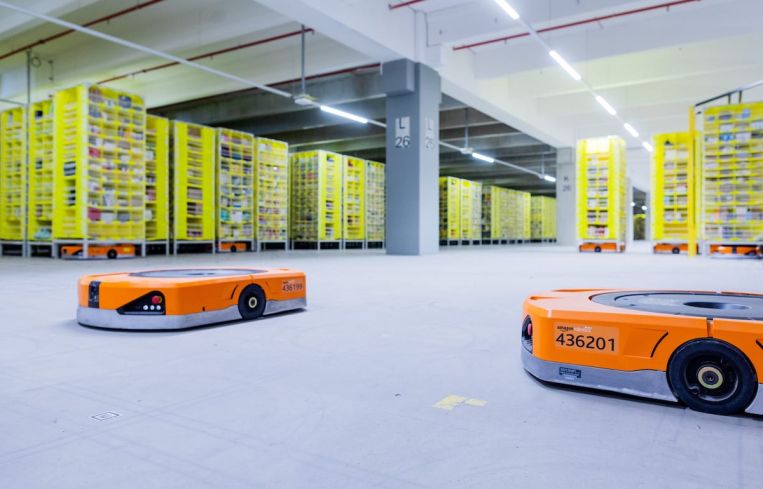 08 December 2020, North Rhine-Westphalia, Mönchengladbach: Robots transport goods to the employees in the warehouse of a logistics center of the mail order company Amazon.