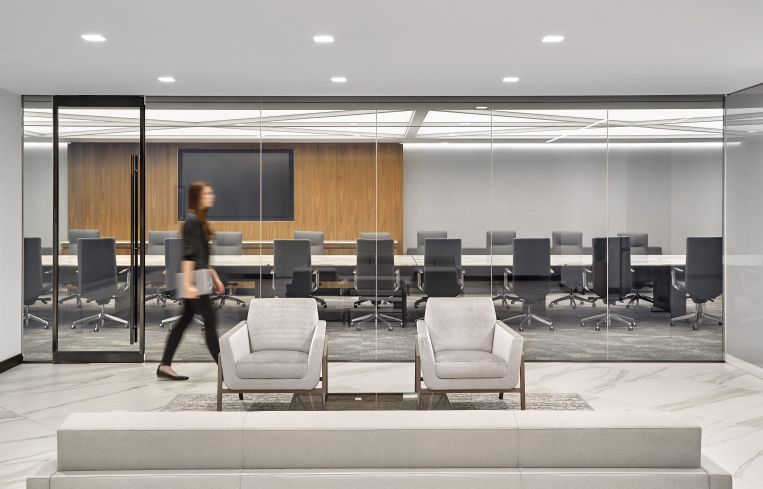 Conference and board rooms have wood panels on the walls, as well as unique furniture like this marble conference table that has an engraving that matches the pattern of the ceiling lights.