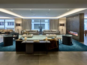 The new 11,000-square-foot amenity center at 100 Park Avenue, designed by Design Republic, includes several different areas, including a lounge space with midcentury modern-inspired furniture. 
