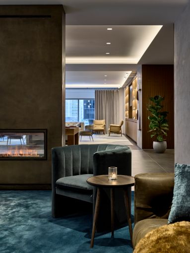 The lounge includes a freestanding faux fireplace (the "fire" is created by a spray of water and LED lighting) that helps divide the space. 