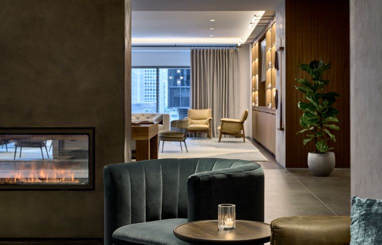 The lounge includes a freestanding faux fireplace (the "fire" is created by a spray of water and LED lighting) that helps divide the space.
