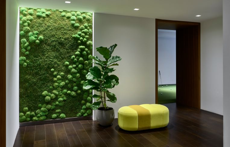 The entry area included a mummified moss wall and a yellow bench, along with a room devoted to a 3D golf simulator.