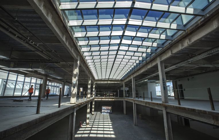 Workers sweep inside the newly added 3rd floor of the vacant Sears store in Santa Monica that has recently undergone a $50 million makeover to turn the Art Deco-style building into an office, restaurant and retail complex.