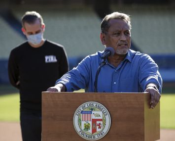Councilmember Gil Cedillo addresses a press conference held at the launch of mass COVID-19 vaccination site at Dodger Stadium in January. This week, the city council approved his motion calling for a plan to immediately freeze rent on residential units with expired or soon-to-expire covenants that limit rent increases.
