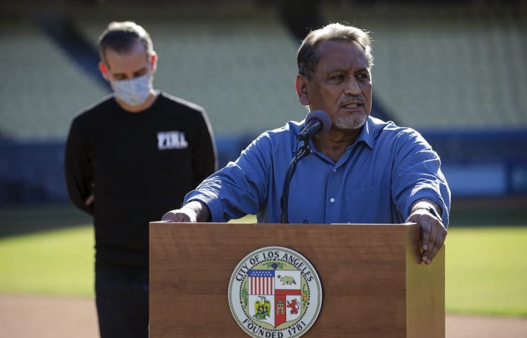 Councilmember Gil Cedillo addresses a press conference held at the launch of mass COVID-19 vaccination site at Dodger Stadium in January. This week, the city council approved his motion calling for a plan to immediately freeze rent on residential units with expired or soon-to-expire covenants that limit rent increases.