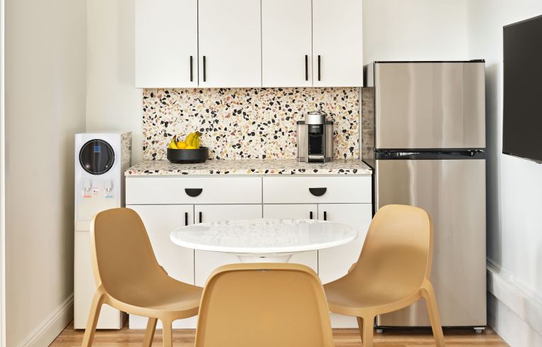 Recycled chairs, a white tulip table and a terrazzo backsplash and counter help give the new kitchen a midcentury modern touch.
