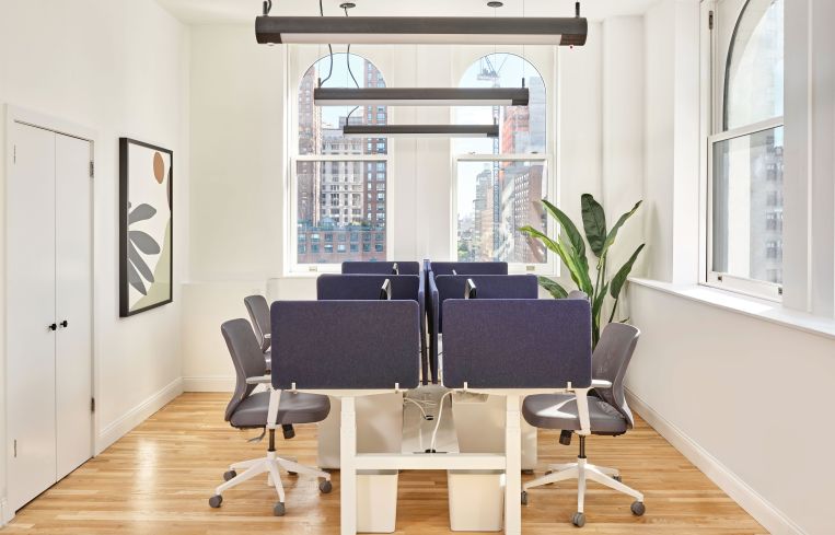 The new 1,000-square-foot office has a small open work area framed by loft windows.