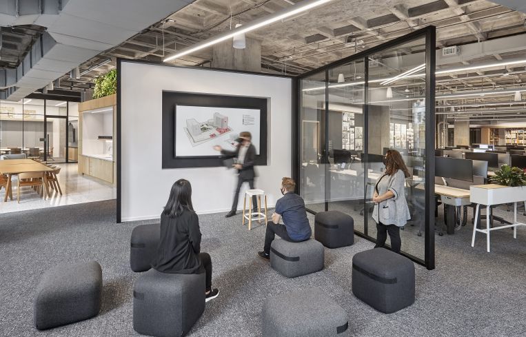 One of the studio's many presentation spaces is the "The Cube," a semi-open meeting room with a glass wall.