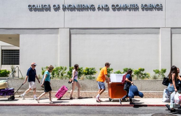 California State University Fullerton students along with the help of their parents and families move their belongings from their vehicles into the residence halls, in Fullerton.