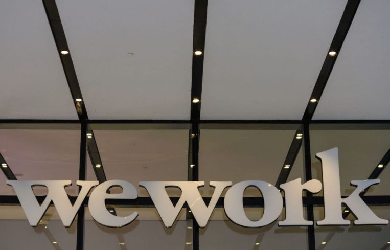 A closeup of a building entrance with the word "WeWork" over it.