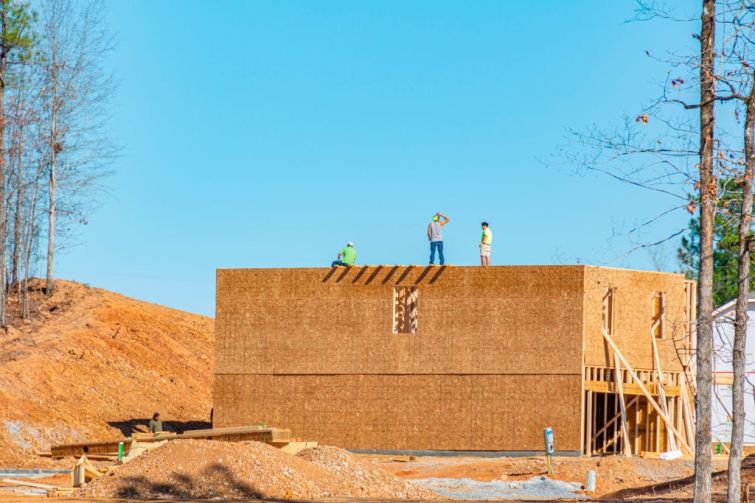 Workers stand a top a new house in Alabama.
