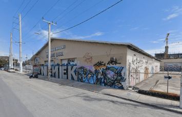 A large building on an empty street covered in graffiti.