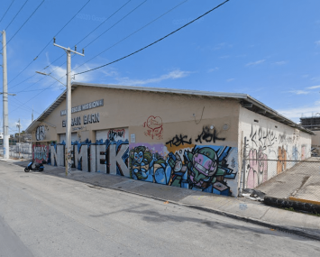 A large building on an empty street covered in graffiti.