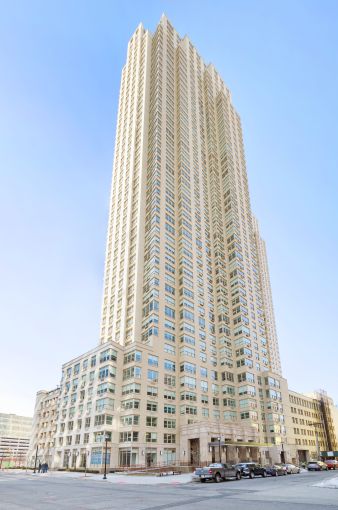 A large white and glass building jutting into an empty blue sky.