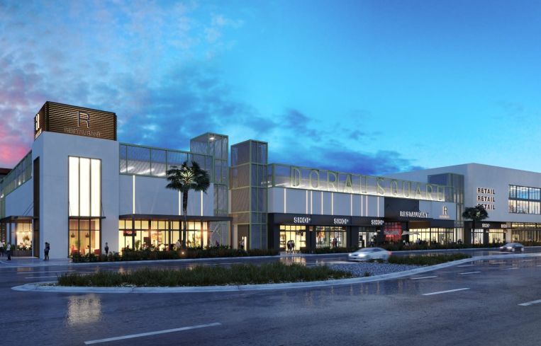 A large mall building in front of a sunset.