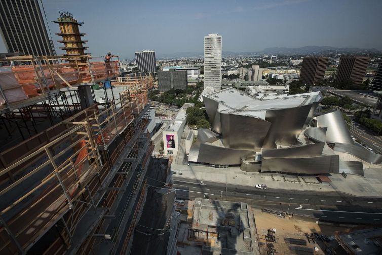 A construction worker checks out the view from the residential tower under construction at The Grand, a Frank Gehry-designed, $1- billion complex on Bunker Hill across the street from the Walt Disney Concert Hall (also designed by Gehry) in the background.
