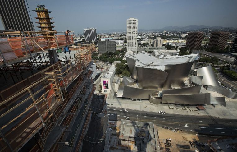 A construction worker checks out the view from the residential tower under construction at The Grand, a Frank Gehry-designed, $1- billion complex on Bunker Hill across the street from the Walt Disney Concert Hall (also designed by Gehry) in the background.