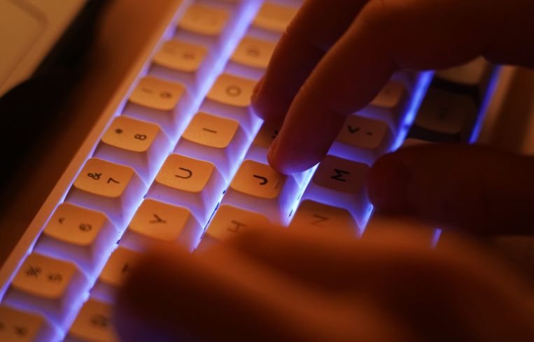 A pair of hands typing on a keyboard.