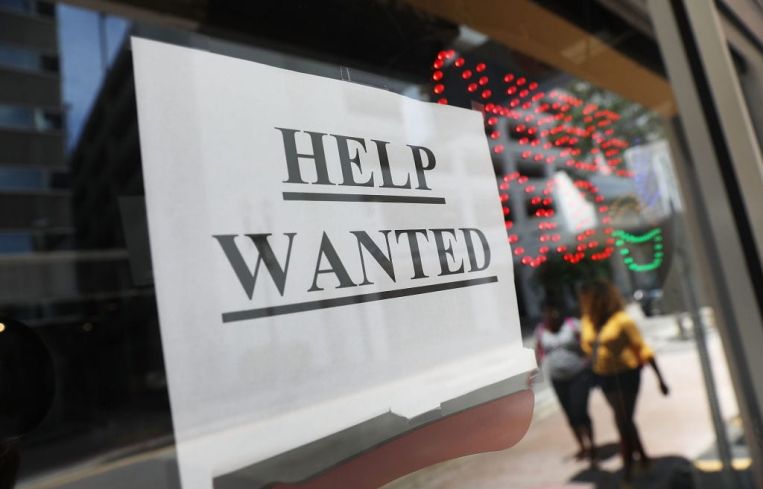 A "help wanted" sign hangs on a window of a restaurant in Miami, Florida.