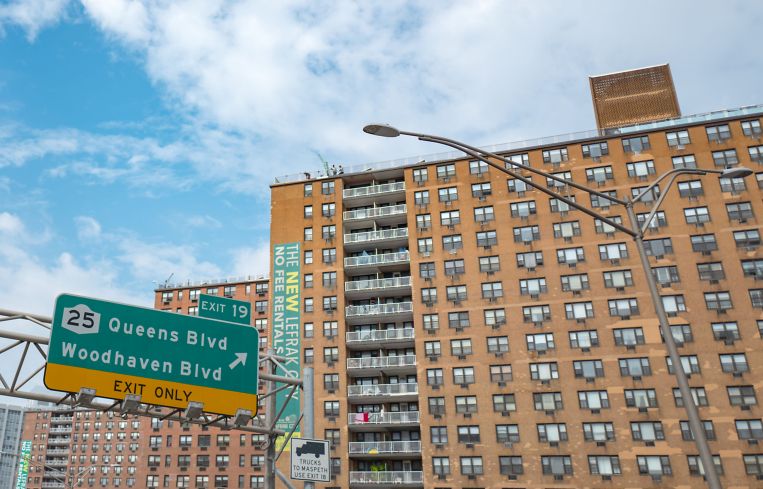 A large, blocky building rising behind highway signs.
