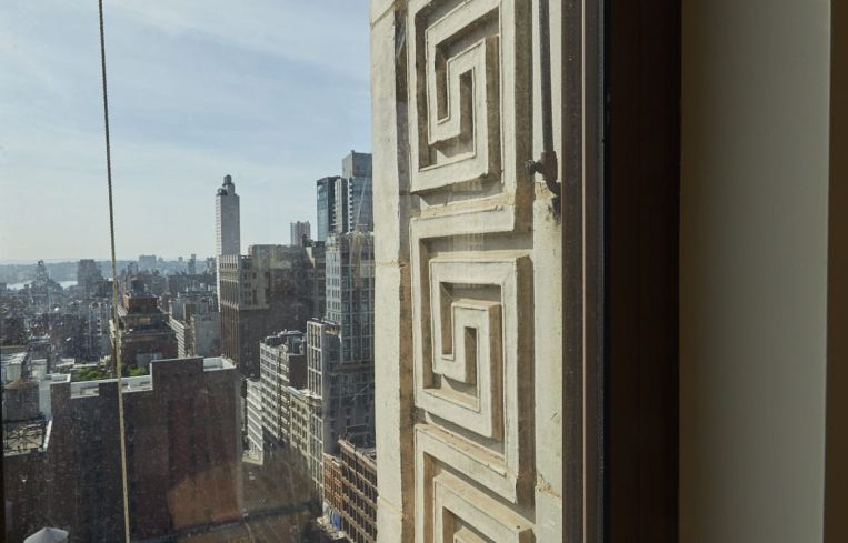 The half-moon windows are set into carved plaster and terra cotta elements that are being restored.