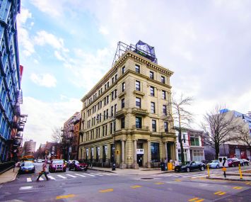 A limestone former bank building at 134 Broadway, near the Williamsburg Bridge, becomes boutique offices with a high-end restaurant on the ground floor and rooftop.