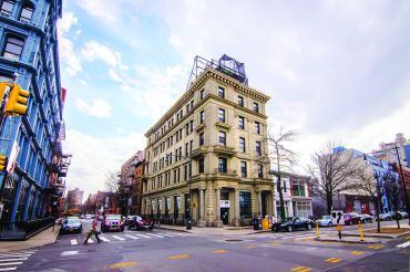 A limestone former bank building at 134 Broadway, near the Williamsburg Bridge, becomes boutique offices with a high-end restaurant on the ground floor and rooftop.
