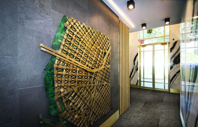 The lobby includes Williamsburg-themed brass sculptures by Kenneth Nilson, such as this wall map.