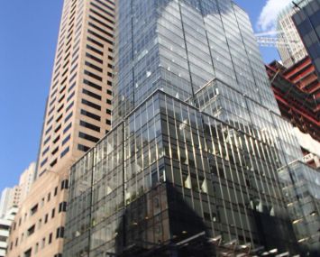 A tall, glass covered grey skyscraper at 565 Fifth Avenue.
