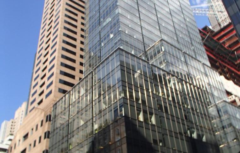 A tall, glass covered grey skyscraper at 565 Fifth Avenue.