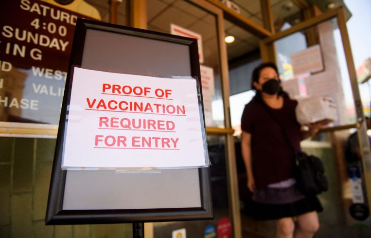 A sign outside a store reading you have to have a COVID vaccine to get inside.
