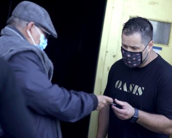 A doorman at Oasis checks a customer's vaccination card before allowing him to enter on July 29. As COVID-19 begins to surge due to the Delta variant, The San Francisco Bar Owner Alliance, which consists of over 500 bars in San Francisco, is implementing a new policy that requires bar customers to show proof of vaccination or a negative COVID-19 test within 72 hours of the bar visit.