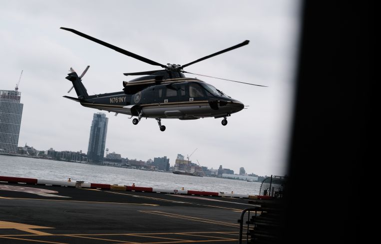 A helicopter taking off next to a river.