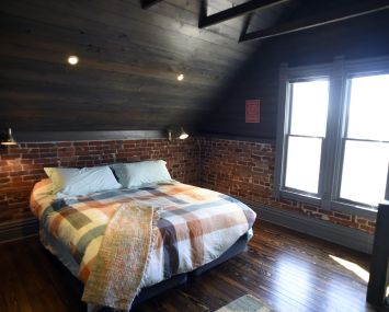 A very clean room with a brick wall and a bed.