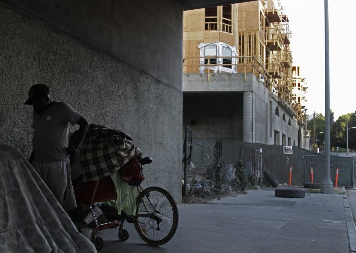Homeless encampment under the freeway on Temple Street and Geoffrey Palmer's Da Vinci Apartments under construction in 2014. Developer Geoffrey Palmer, known for the faux Italiante apartment blocks such as the Orsini and the Medici has sued the city over its eviction moratorium.