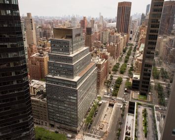 A tall, rectangular silver building in Midtown with a large, rectangular base and several slightly smaller floors as the building rises.