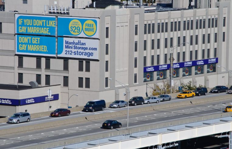A big billboard next to a highway.