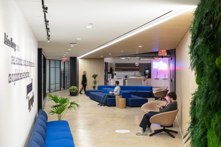 Long blue couches near the kitchen offer more places to work and host all-hands meetings. 