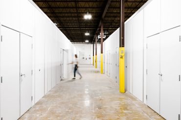 A hallway with storage sheds on either side.