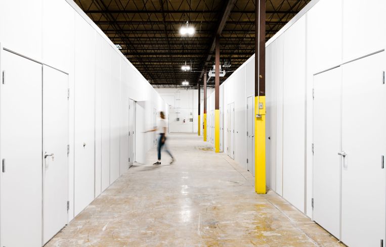 A hallway with storage sheds on either side.