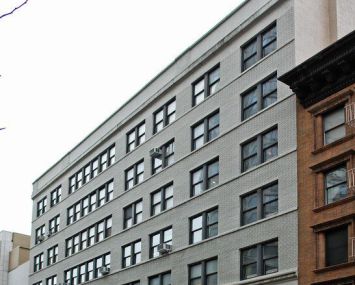 A large grey office building on an empty street.
