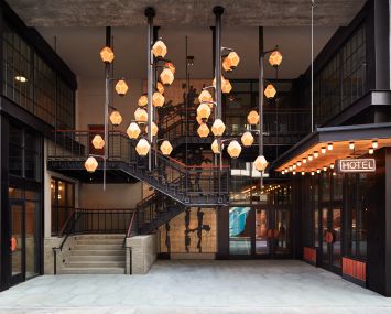 The new Ace Brooklyn has lantern-like pendant lights and a two-level entrance with a neon "Hotel" sign.