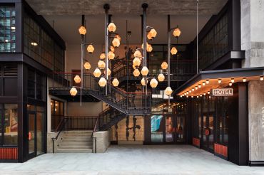 The new Ace Brooklyn has lantern-like pendant lights and a two-level entrance with a neon "Hotel" sign. 