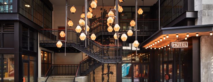 The new Ace Brooklyn has lantern-like pendant lights and a two-level entrance with a neon "Hotel" sign.