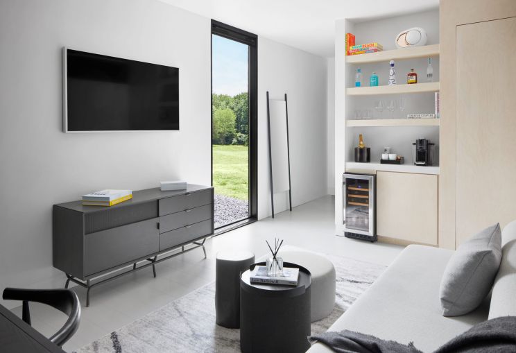 The 400-square-foot rooms feature modular furniture, king-size beds, a small living room furniture setup with a 55" television, and a small wine fridge. 