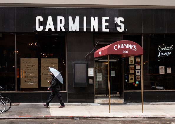 A person holds an umbrella outside Carmine's Italian Restaurant in Times Square