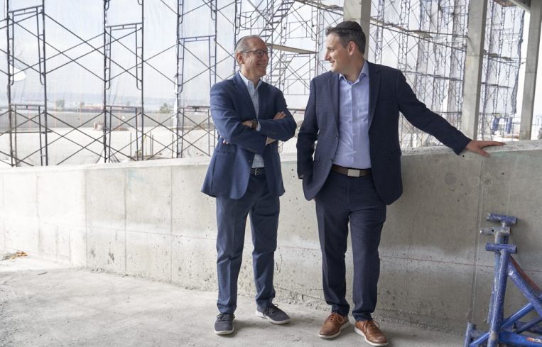 Two men standing in a warehouse.